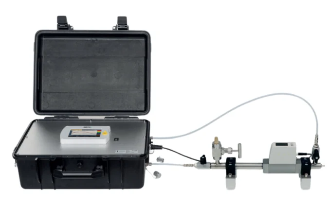 Portable compressed air quality measurement kit: hard case with a readout instrument connected by hose to an in-line sampling section with valve and sensor.